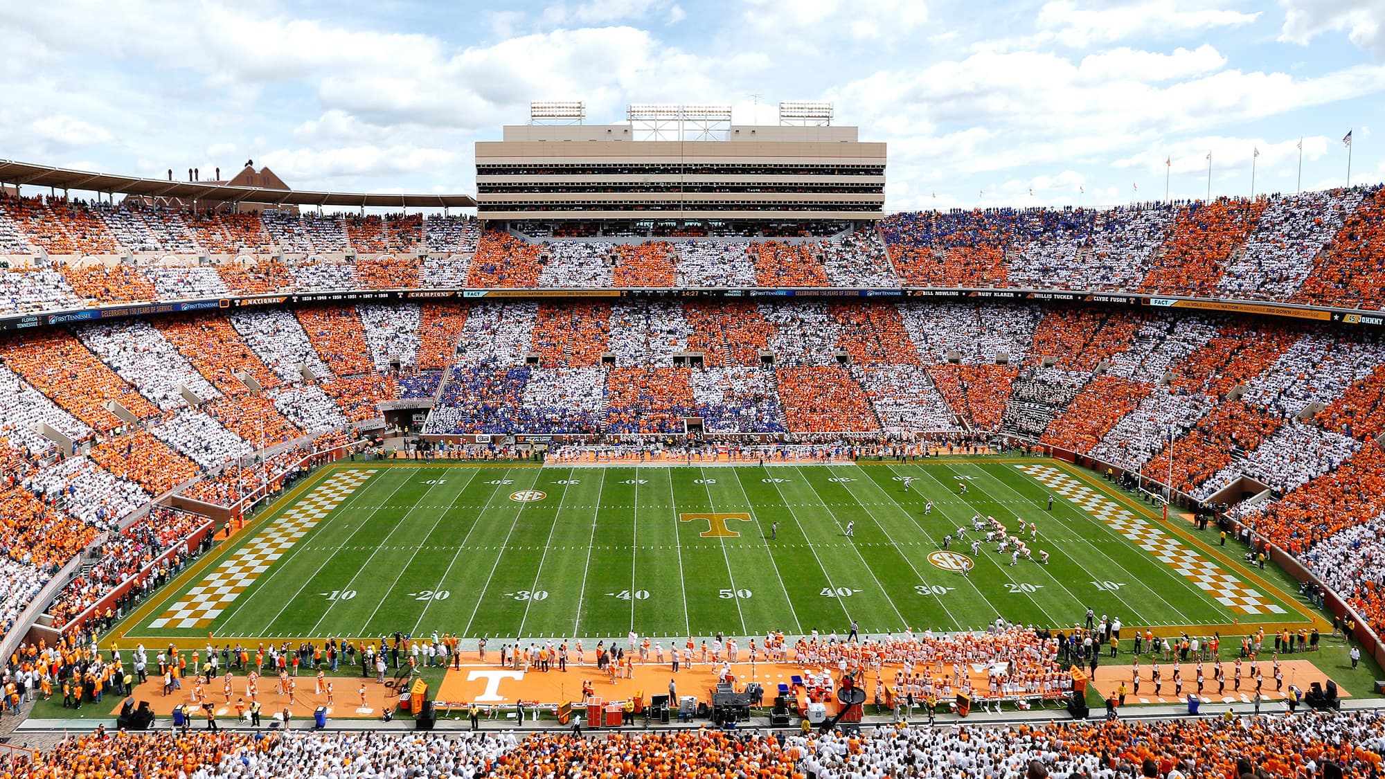 A packed college football stadium under the lights